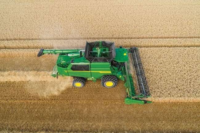 Luftaufnahme eines Mähdreschers bei der Weizenernte mit breitem Erntevorsatz für saubere Erntegutreihen