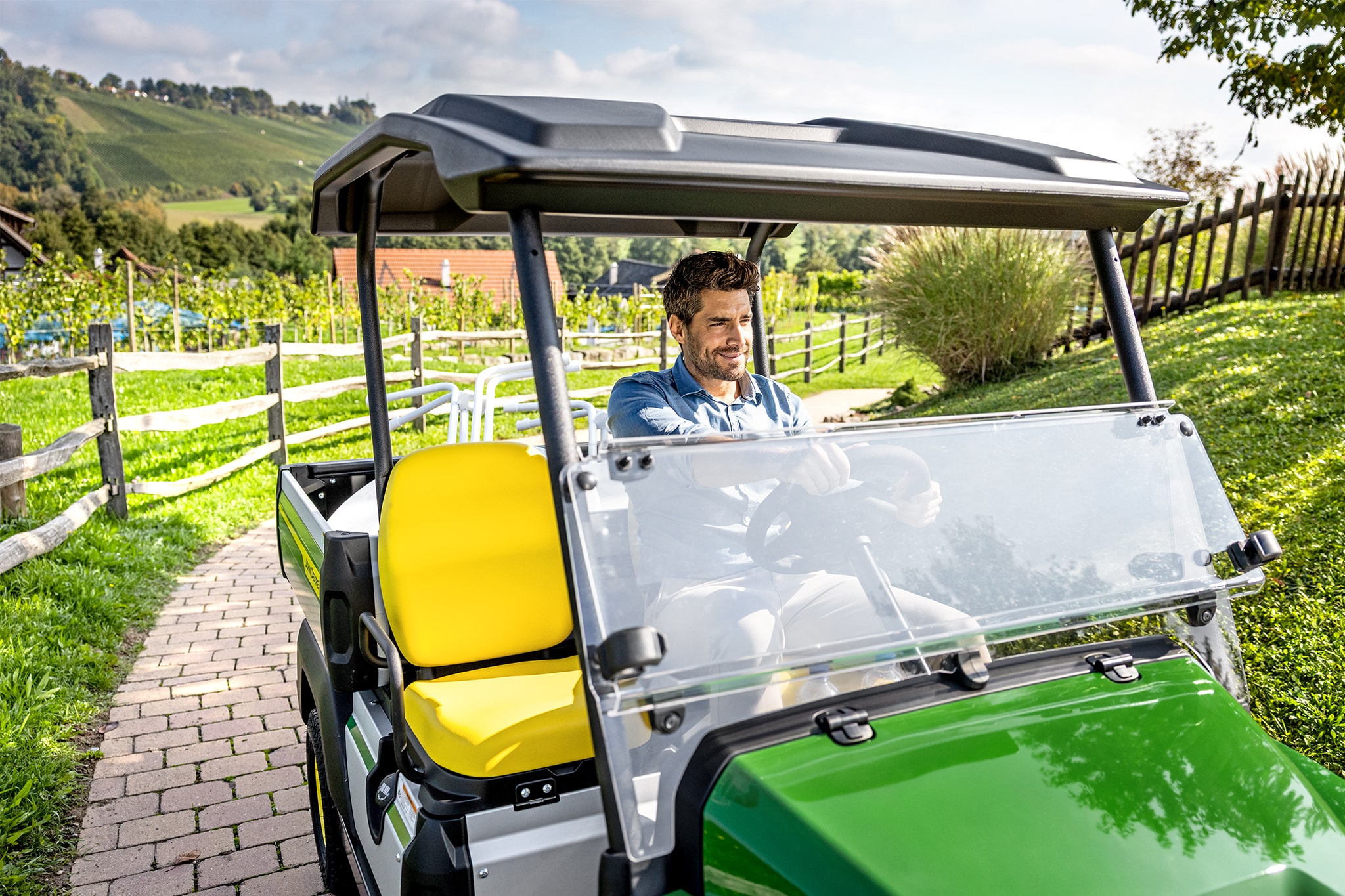 Nahaufnahme des Innenraums eines John Deere Gator GS mit gelben Sitzen und Lenkrad Nahaufnahme des Innenraums eines John Deere Gator GS mit gelben Sitzen und Lenkrad