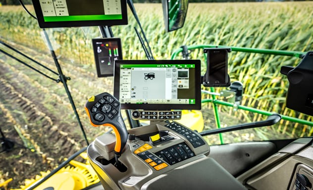 Ensileuse automotrice F9 700 chargeant une remorque Joskin tirée par un tracteur John Deere 6R