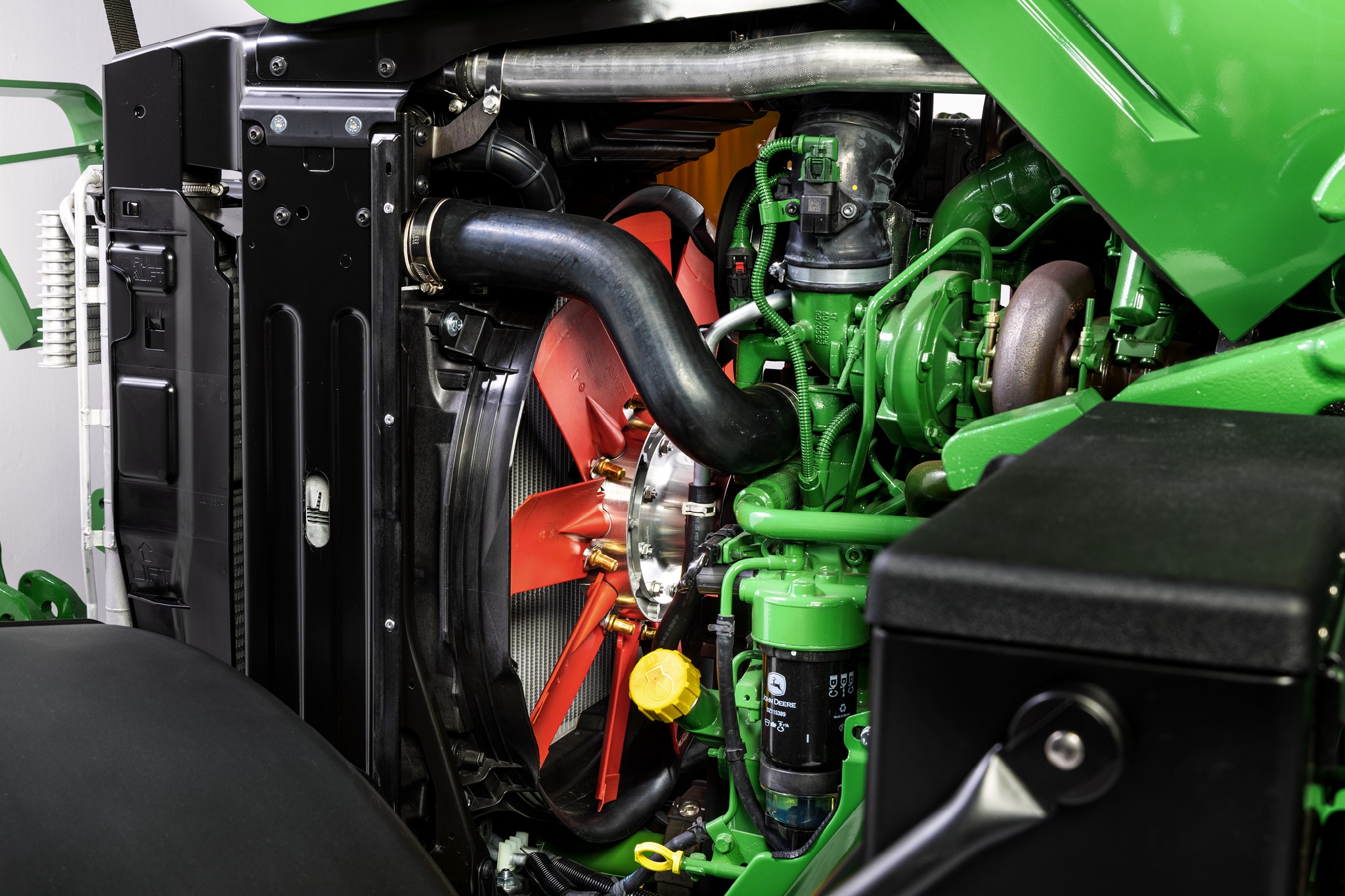 Gros plan sur le compartiment moteur de la série&nbsp;6M de John&nbsp;Deere, mettant en évidence le circuit de refroidissement et les composants du moteur.